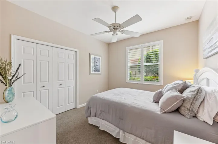 Carpeted bedroom featuring a closet and a ceiling fan