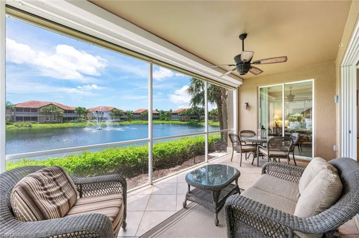 Sunroom / solarium with a water view, ceiling fan, and a residential view