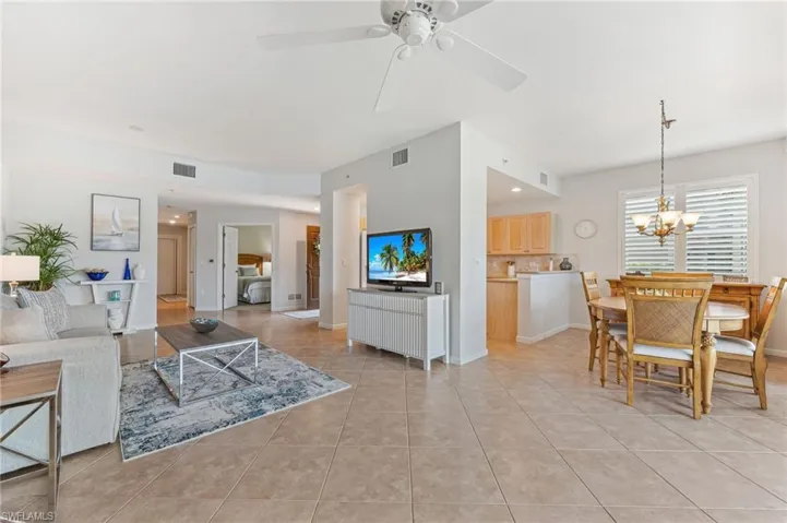 Living area featuring light tile patterned floors, a chandelier, and ceiling fan