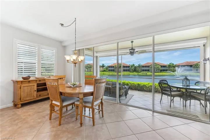 Dining room featuring a chandelier, light tile patterned floors, a water view, and ceiling fan