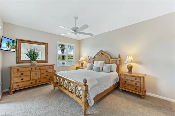 Bedroom with light carpet and a ceiling fan
