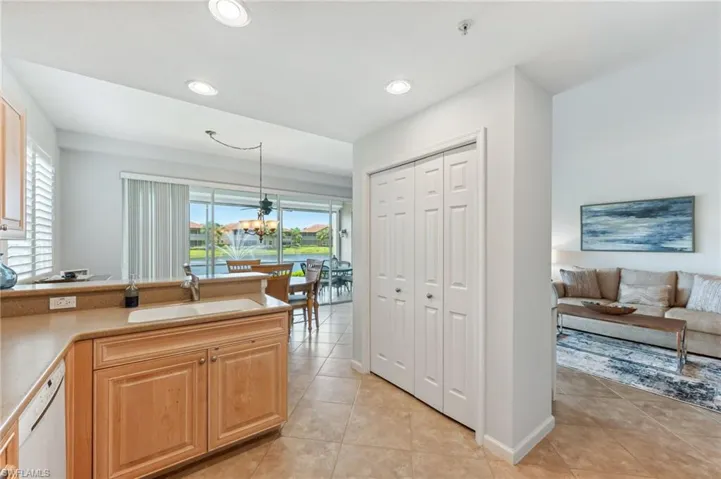 Kitchen featuring white dishwasher, light tile patterned floors, decorative light fixtures, a chandelier, and open floor plan
