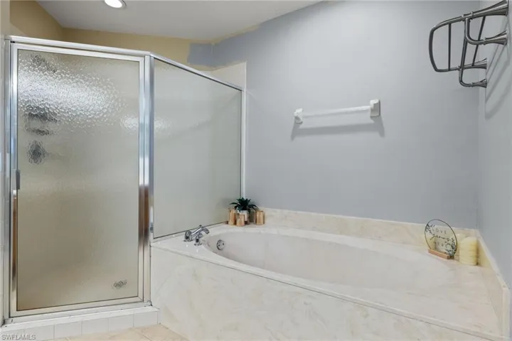 Bathroom with independent shower and bath and tile patterned floors