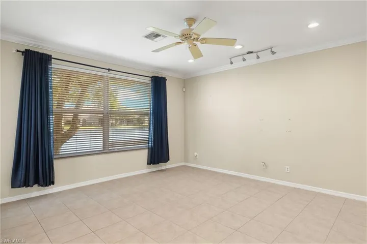 Tiled spare room with ornamental molding and ceiling fan