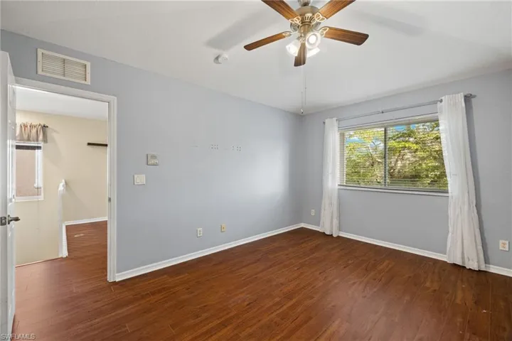 Unfurnished room with ceiling fan and dark hardwood / wood-style floors