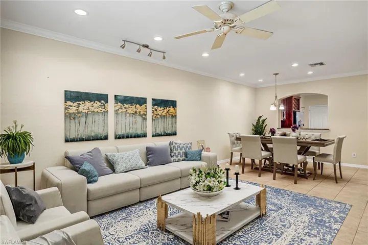 VIRTUALLY STAGED -Tiled living room with ornamental molding and ceiling fan