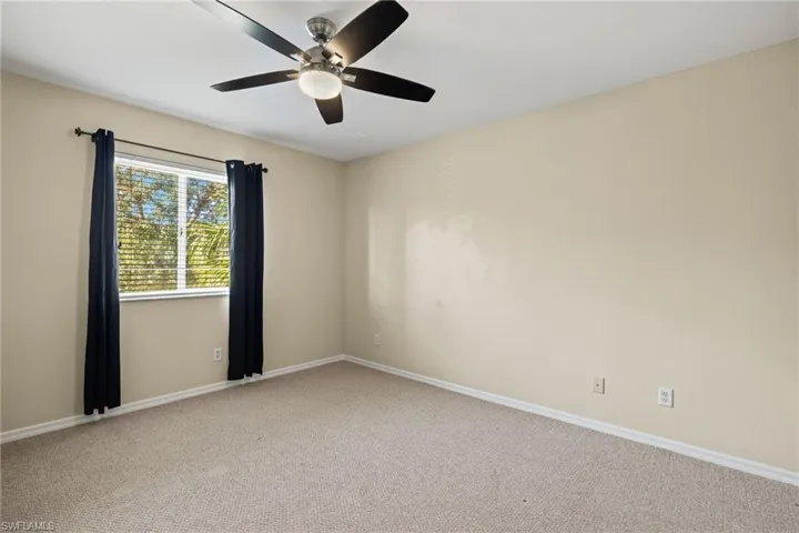 Unfurnished room with ceiling fan and carpet