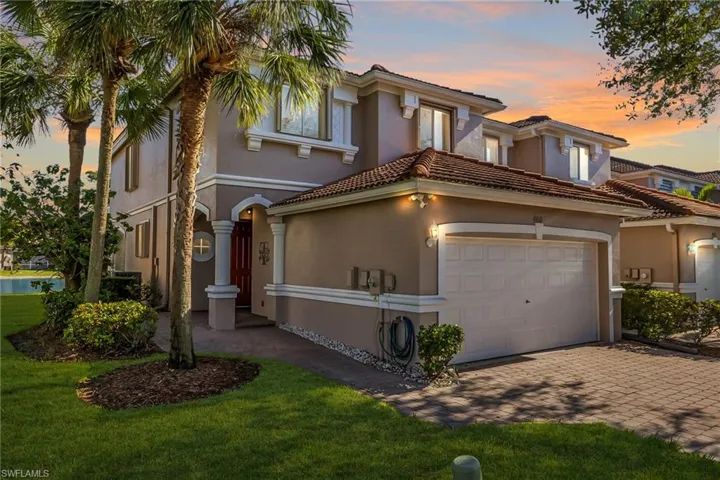 Mediterranean / spanish home with a garage and a yard