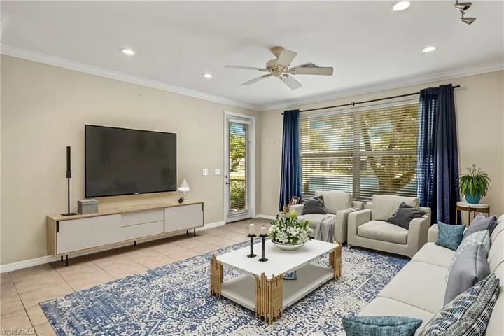 VIRTUALLY STAGED -Living room featuring light tile patterned flooring, ceiling fan, and ornamental molding