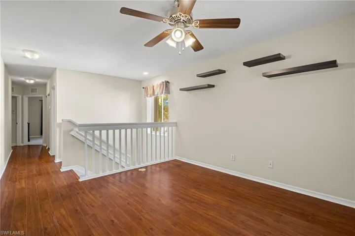 Spare room with wood-type flooring and ceiling fan