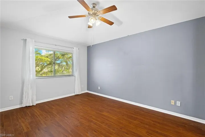 Spare room featuring dark hardwood / wood-style flooring and ceiling fan