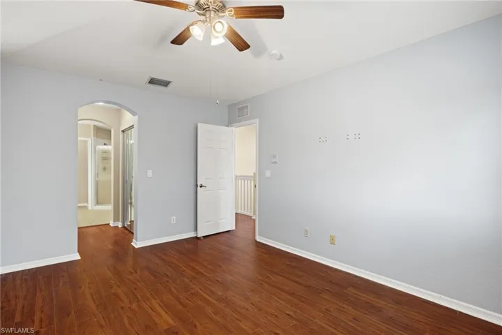 Unfurnished bedroom featuring dark hardwood / wood-style flooring and ceiling fan