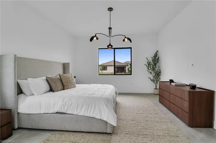Bedroom with light tile patterned floors and a chandelier