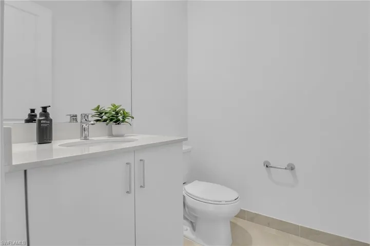 Half bathroom with vanity and tile patterned flooring