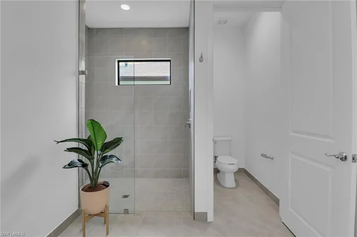 Full bath featuring tiled shower and tile patterned floors