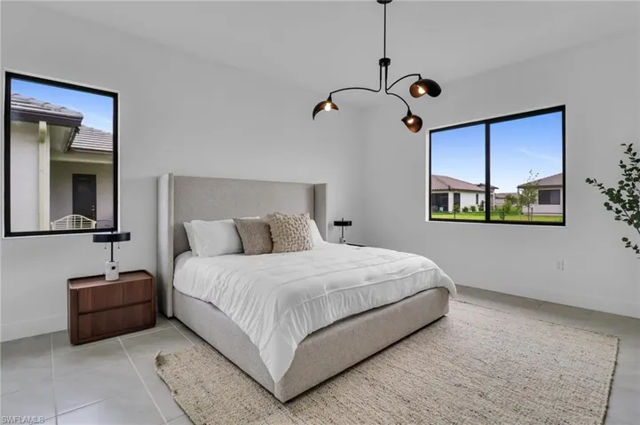 Bedroom with tile patterned flooring, multiple windows, and a chandelier