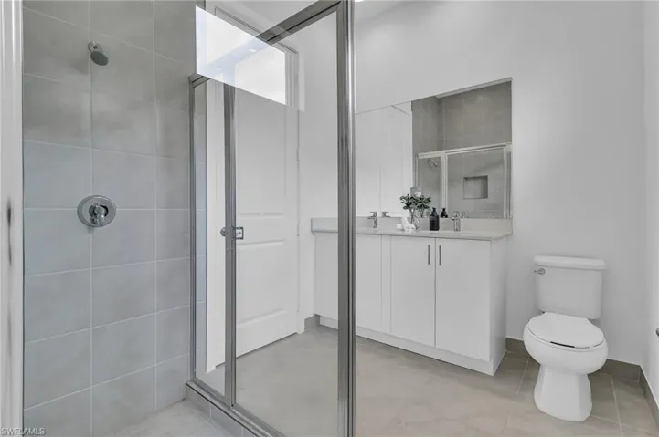 Bathroom featuring a shower stall, vanity, and tile patterned flooring