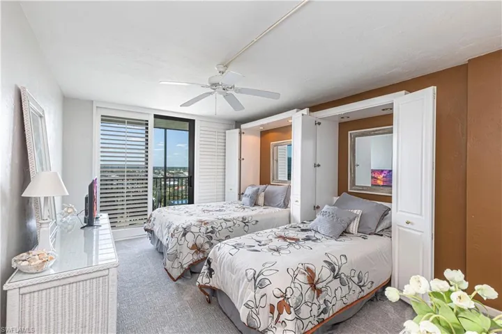 Carpeted bedroom with multiple windows, access to exterior, and a ceiling fan