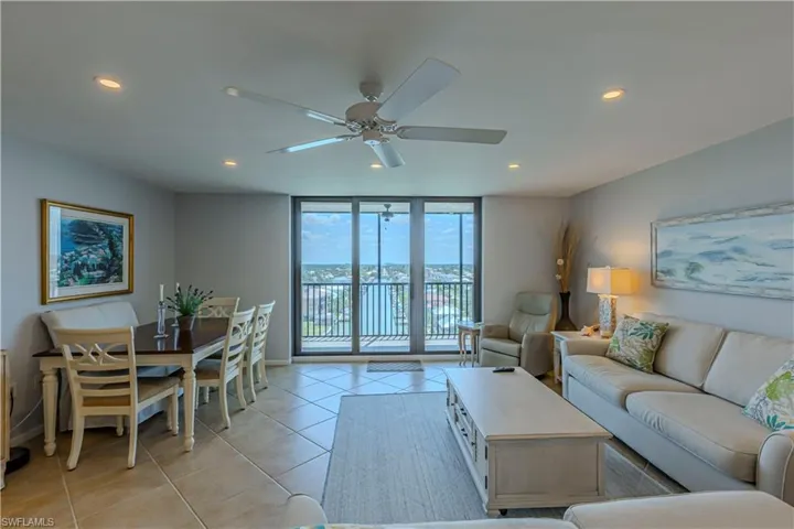 Living area with recessed lighting, light tile patterned flooring, ceiling fan, floor to ceiling windows, and baseboards