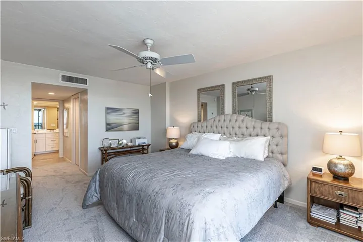 Bedroom with light carpet, baseboards, and ceiling fan