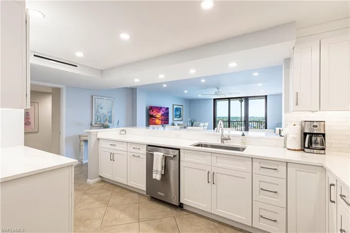 Kitchen featuring dishwasher, a sink, recessed lighting, light tile patterned floors, and white cabinetry