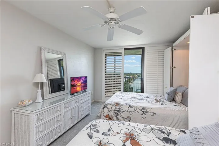 Carpeted bedroom featuring access to exterior, ceiling fan, and baseboards