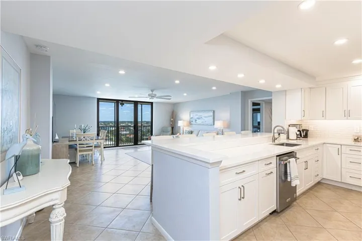 Kitchen featuring stainless steel dishwasher, recessed lighting, light tile patterned flooring, a sink, and backsplash