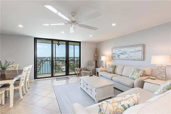 Living room with light tile patterned floors, recessed lighting, a ceiling fan, and expansive windows