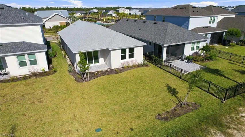 Backyard featuring a paved patio, metal perimeter fencing, and established lawn