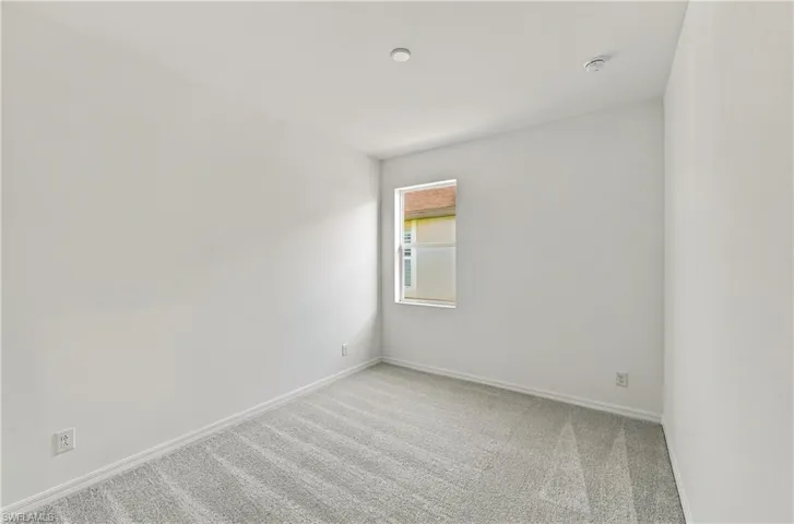 Neutral interior space featuring crisp white walls, high-pile carpeting, and a single-hung window with a neutral frame