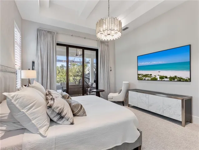 Bedroom with access to exterior, carpet floors, and a chandelier