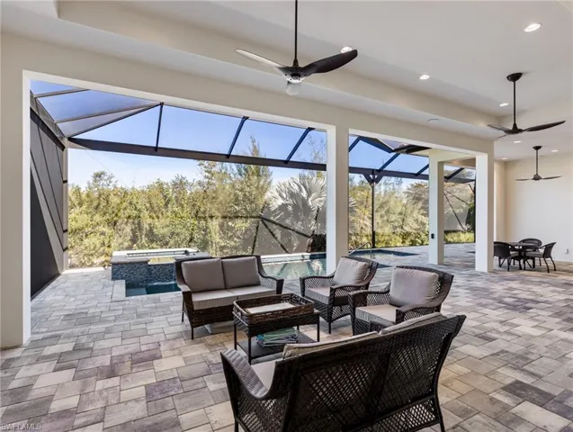 View of patio featuring ceiling fan, an outdoor living space, a sunroom, glass enclosure, and a pool with connected hot tub