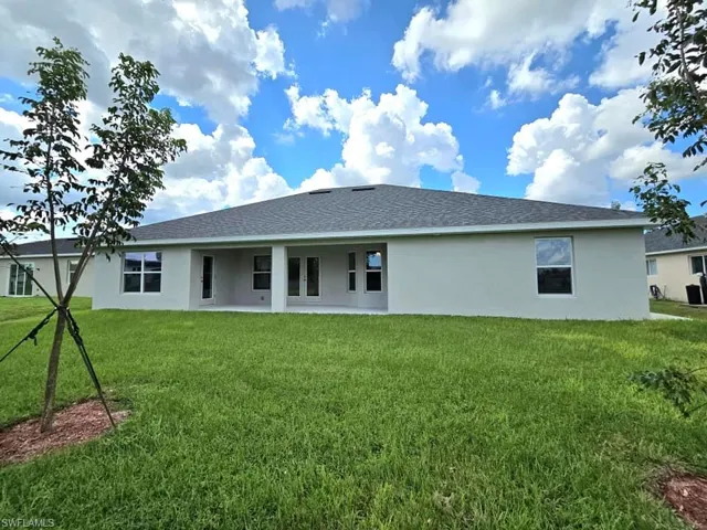 Rear view of house featuring a lawn