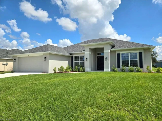 View of front of home featuring a front yard and a garage