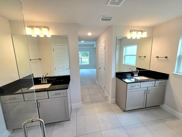 Bathroom with vanity, tile patterned flooring, and a wealth of natural light