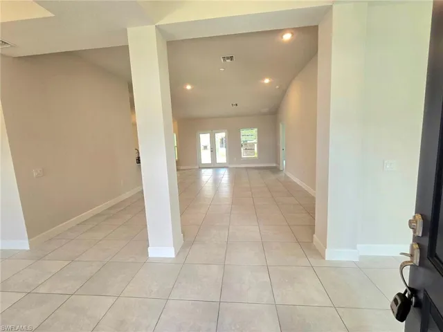 Tiled foyer featuring french doors