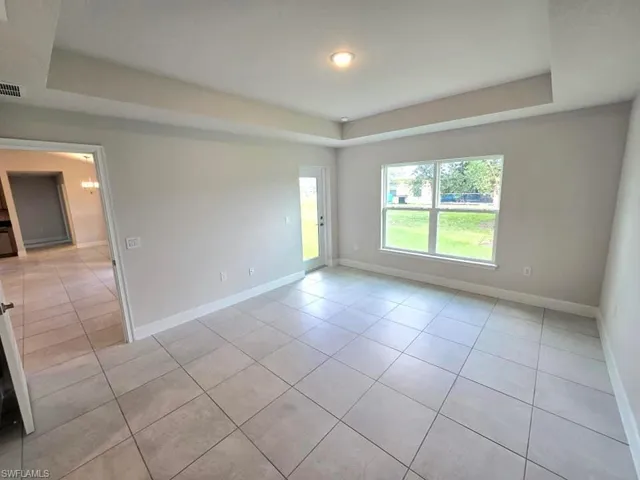Tiled empty room with a raised ceiling