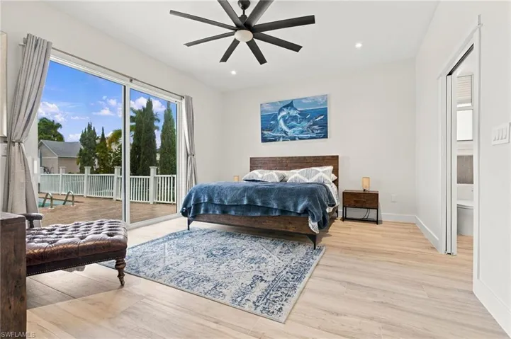 Wood-finish flooring, sliding glass door, recessed lighting, and modern multi-blade ceiling fan