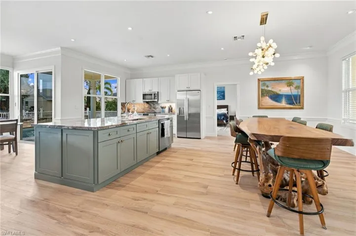 Kitchen featuring a center island with stone-style countertops, shaker-style cabinetry, stainless steel appliances, recessed lighting, and wood-finish flooring