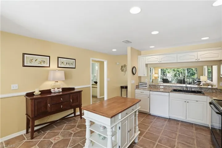 Kitchen featuring black appliances, white cabinets, recessed lighting, light stone countertops, and light tile patterned floors