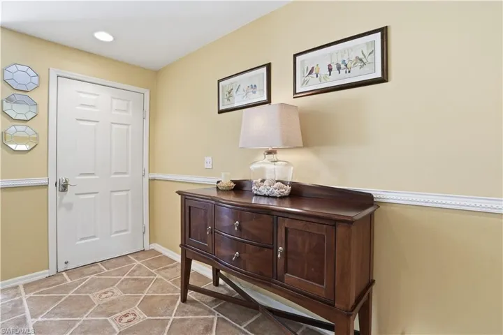 Living area featuring lofted ceiling, light carpet, and a ceiling fan