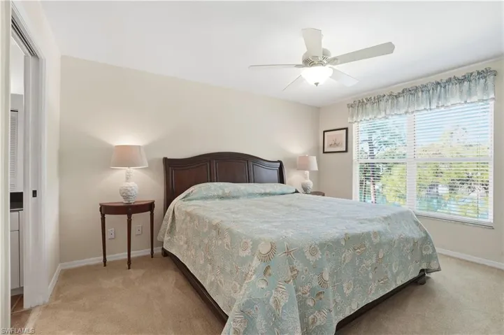 Bedroom with ceiling fan and light carpet