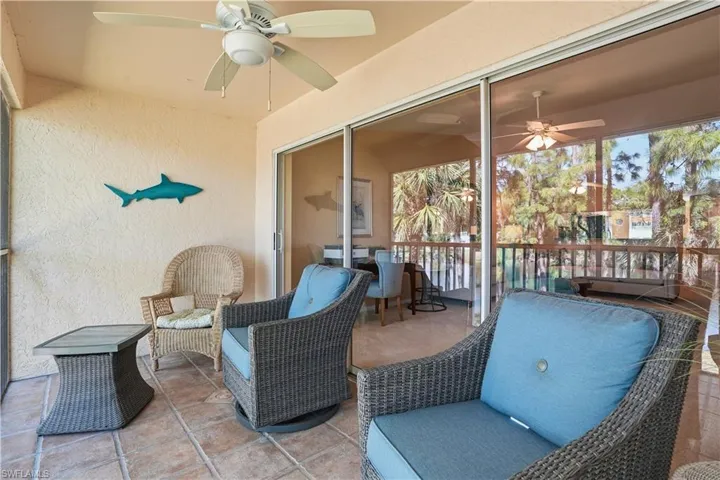 Sunroom / solarium featuring a ceiling fan and a water view