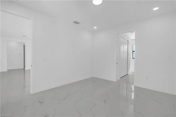 Empty room with recessed lighting and light marble finish flooring