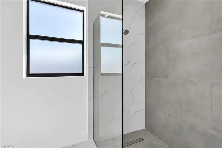 Bathroom with a marble finish shower