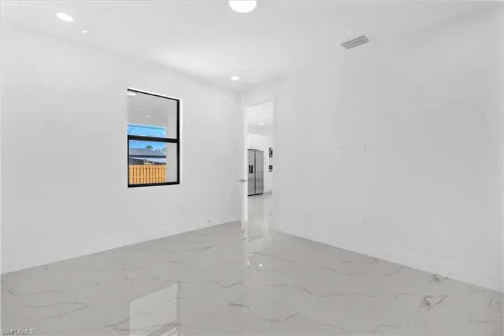 Unfurnished room featuring recessed lighting and light marble finish flooring