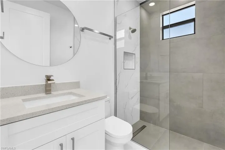 Full bathroom featuring vanity and a marble finish shower
