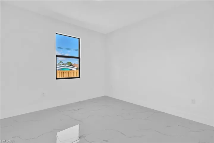 Spare room with baseboards and light marble finish flooring