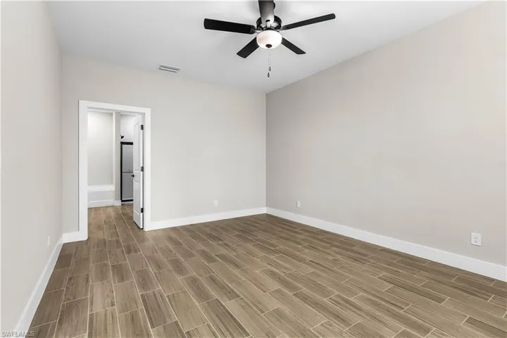 Unfurnished room with wood finish floors and a ceiling fan