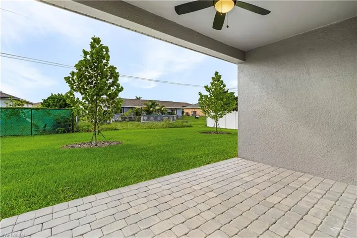 Fenced backyard with a patio and a ceiling fan